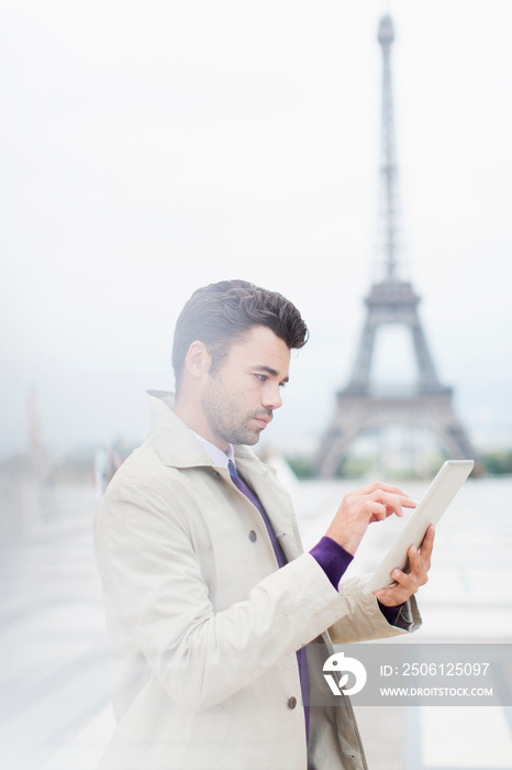 Businessman using digital tablet near Eiffel Tower, Paris, France