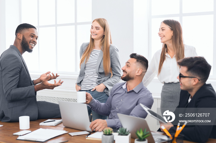 Multiracial work team tlking during coffee break