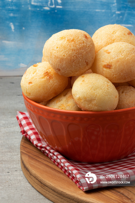 Traditional Brazilian snack cheese bread (pão de queijo) in orange bowl.