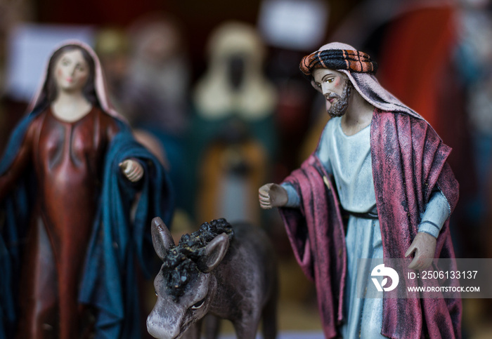 Nativity scene with Joseph figure next to donkey and mother Mary