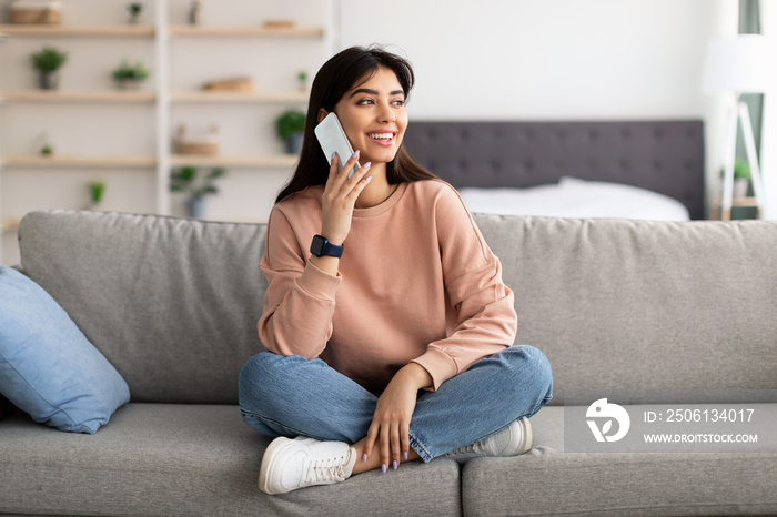 Portrait of smiling woman talking on phone at home