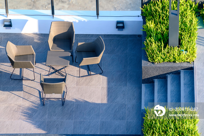 Outdoor gardening design. Top view of wooden chairs and table on green artificial grass in vintage s