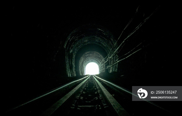 火车隧道。洞穴里的旧铁路。生命的希望在尽头。机车列车的铁路