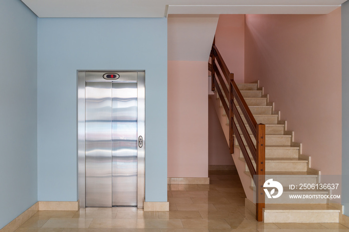 view of the elevator and stairwell in the entrance of a residential building