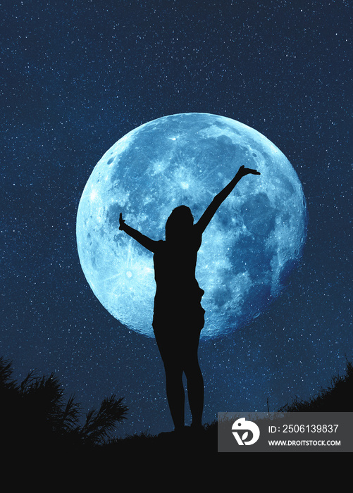 月光之夜，一个双手举在空中的女孩的剪影。