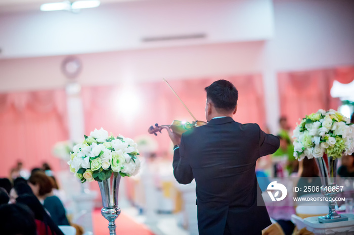 Musician, Violinist is playing violin in the wedding party. atmosphere of romantic and love. The orc