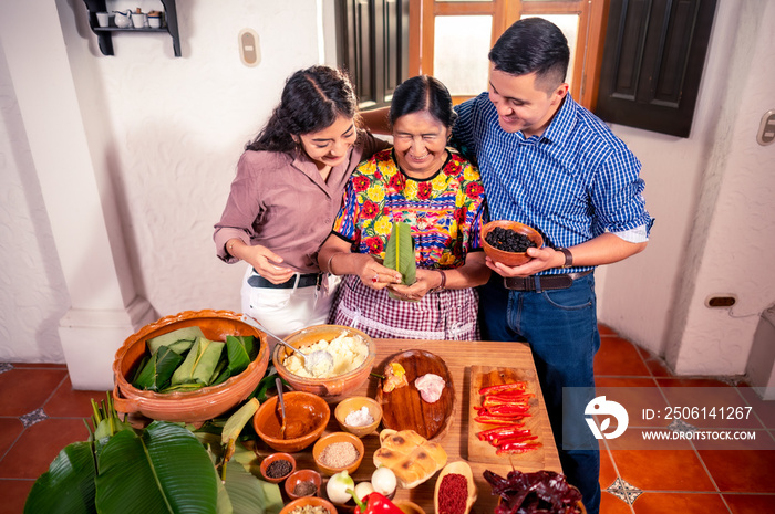 Abuela enseña a sus nietos universitarios a cocinar tamales, platillo tradicional de Guatemala.