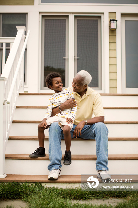 Senior man with his grandson sitting on stairs