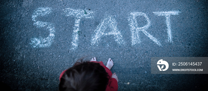 Start in life. Top view of cute little child girl standing before a starting. Selective focus on des