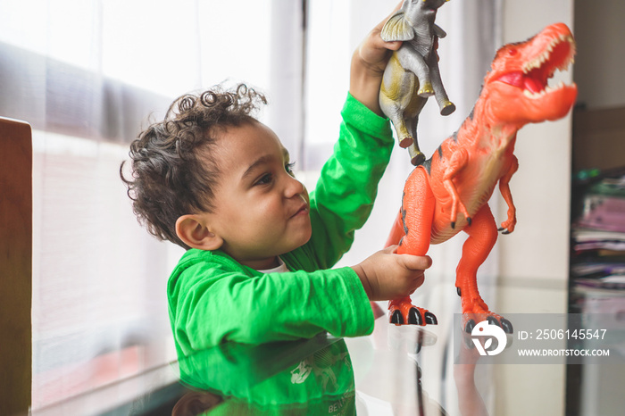 Latin American Boy Playing with Animal Toys at Home.