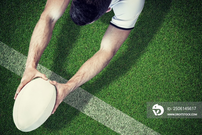 Composite image of high angle view of man holding rugby ball