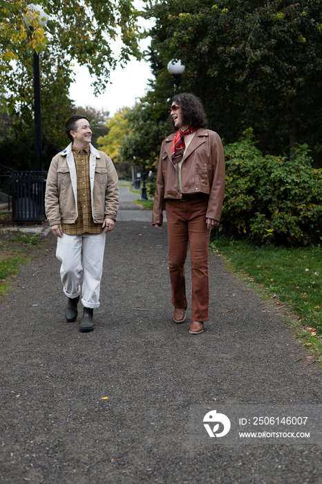 lifestyle image of transgender nonbinary friends talking and walking in the park