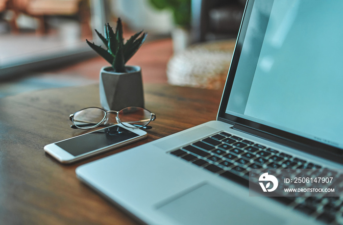 Image of the work environment at home. Freelance. On the table is a laptop, phone and glasses.