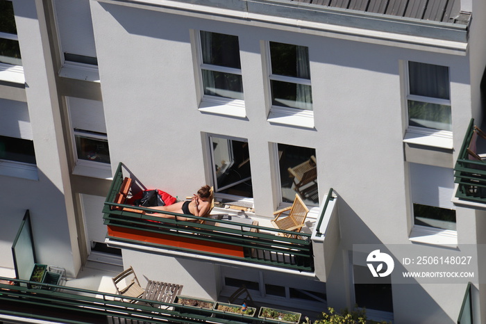 Jeune femme bronzant sur un balcon à Paris