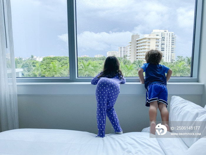 Kids looking out the window on a cloudy day