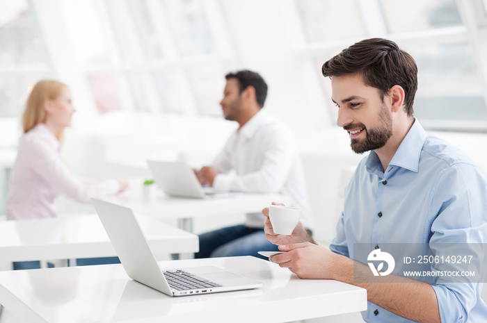 Businessman drinking coffee while working