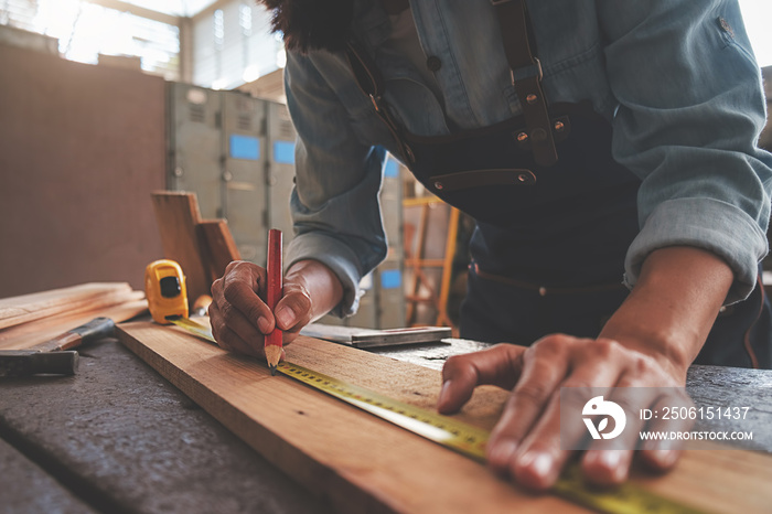 Carpenter working with equipment on wooden table in carpentry shop. woman works in a carpentry shop.