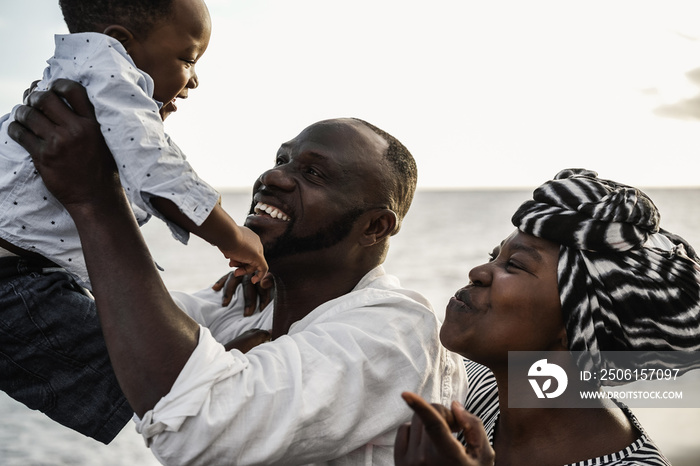 African family playing on the beach in summer vacation - Focus on kid face