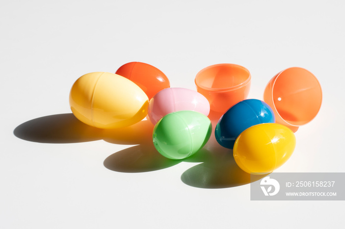 Colorful plastic Easter eggs in the sun isolated on a white background.