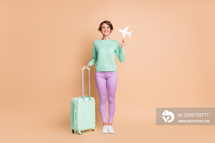 年轻女孩拿着行李飞机的全身照片正面微笑出国旅行