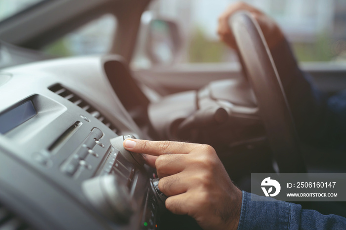近距离手动打开汽车收音机收听。汽车驾驶员更换车辆上的转向按钮电台