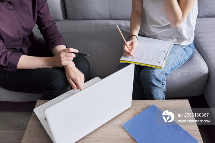 Close-up of student studying individually with teacher, focus on hands with notebook and pencil