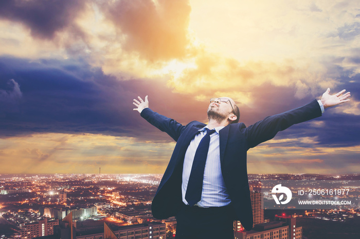 businessman celebrates freedom success arms raised looking up to