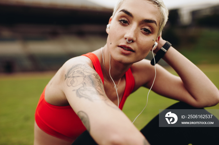 Close up of a fitness woman listening to music on earphones