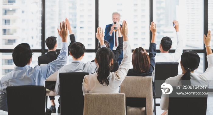 Group of business people raise hands up to ask question and answer to speaker in the meeting room se