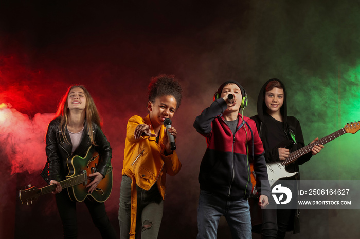 Band of teenage musicians on dark background