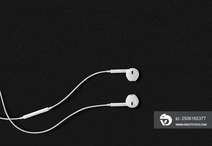 white earphone for listening on black paper background