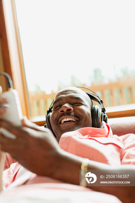 非裔美国人躺在沙发上听音乐
