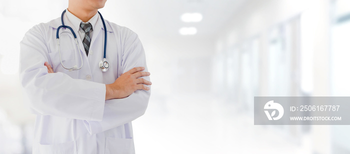 Portrait of smiling Asian medical male Doctor standing in front of blurred interior hospital examina