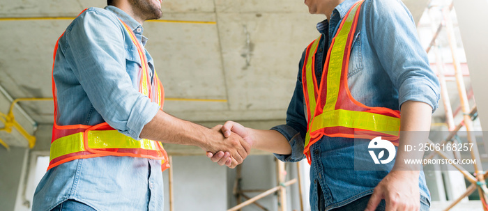 Two Civil Engineer or Architect wearing helmet and handshaking together .architecture and home renov