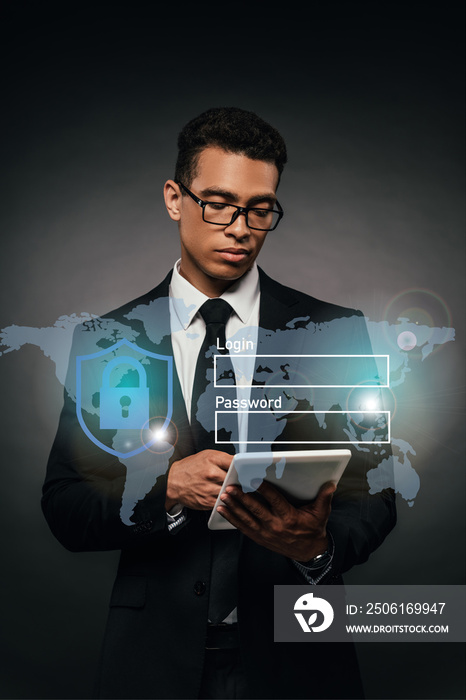 african american businessman in glasses using digital tablet on dark background with cyber security 