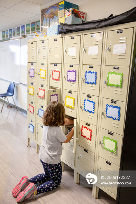 Young girl putting items away in a locker