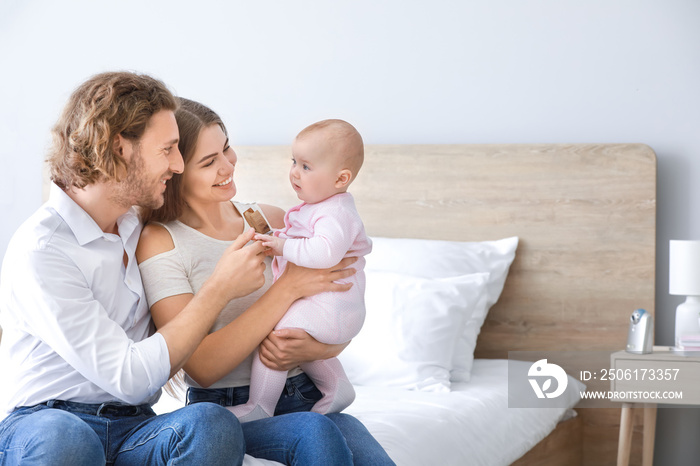 Happy parents with cute little baby at home