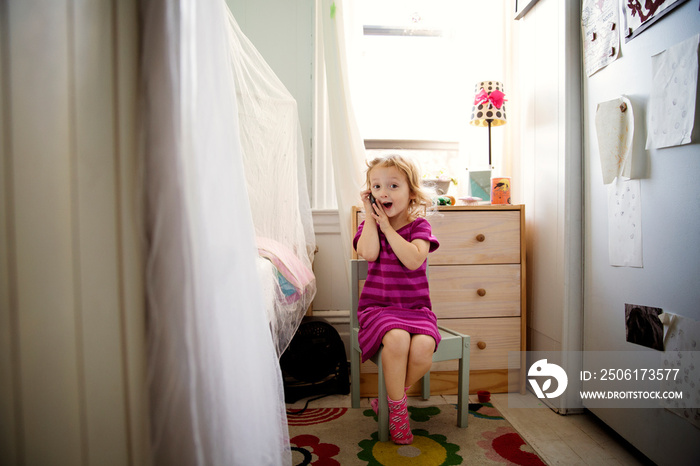 Girl talking on phone in bedroom