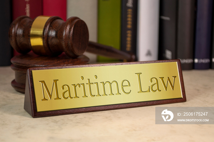 Golden sign with gavel, law books and maritime law