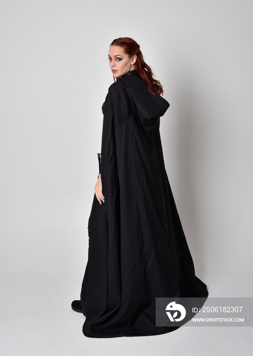 一个穿着黑色长斗篷的女人的幻想肖像。背对ca的全身站立姿势