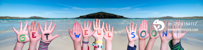 Children Hands Building Colorful English Word Get Well Soon. Ocean And Beach As Background