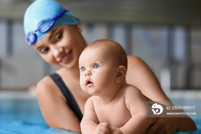 Adorable little baby with coach in swimming pool, closeup