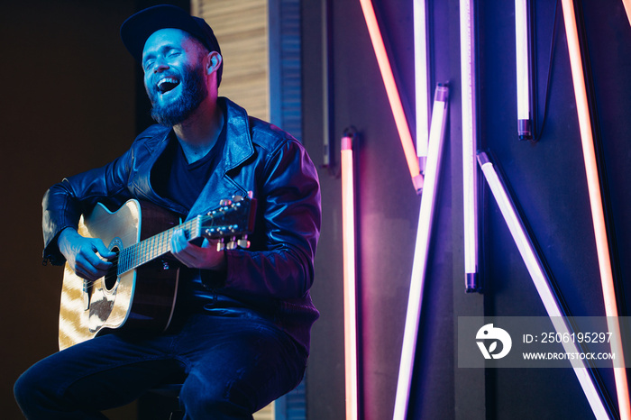 Rocker singing on a stage and playing the guitar in neon lights