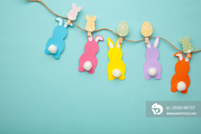 Easter rabbits handmade from colored paper on a rope with clothespins easy crafts for children on a 