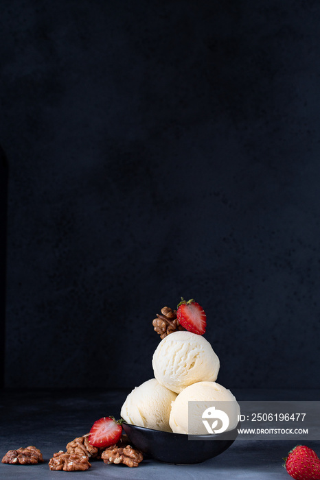 ice cream balls  with strawberries and walnuts on a dark background, selective focus and copy space,