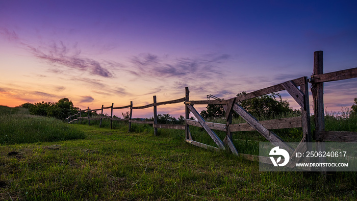 Blue-colored twilight, old wooden fence in the foreground