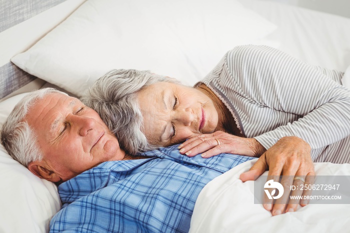 Senior couple sleeping on bed