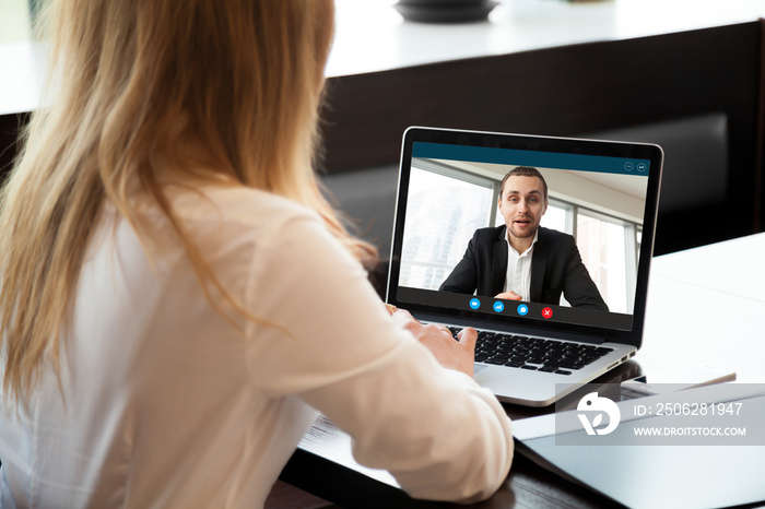 Businesswoman making video call to business partner using laptop, looking at screen with virtual web