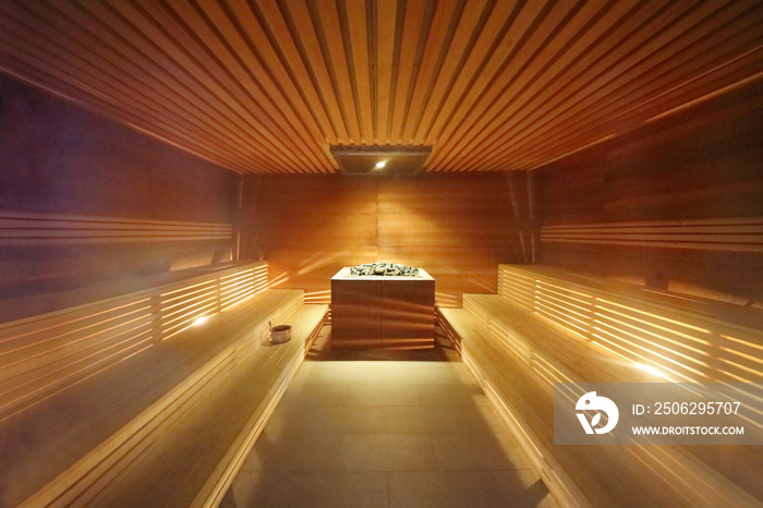 Interior inside the sauna room with wooden benches and hot stones