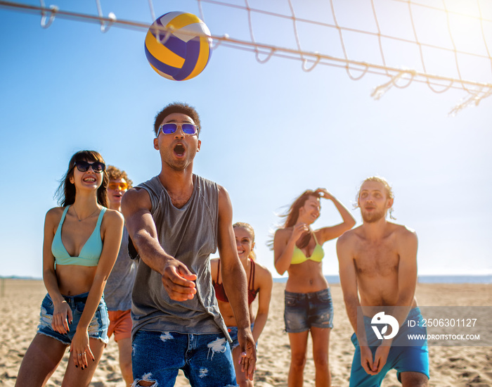 Group of friends playing at beach volley at the beach